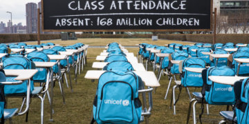 On 1 March 2021, a view of UNICEF’s ‘Pandemic Classroom’ installation at United Nations Headquarters in New York, United States of America.

To call attention to the education emergency wrought by the COVID-19 pandemic, and to and raise awareness of the need for governments to keep schools open, UNICEF unveiled ‘Pandemic Classroom’ – a model classroom made up of 168 empty desks, each seat representing one million children living in countries where schools have been almost entirely closed since the onset of lockdowns. “With every day that goes by, children unable to access in-person schooling fall further and further behind, with the most marginalized paying the heaviest price,” said UNICEF Executive Director Henrietta Fore. “No effort should be spared to keep schools open, or prioritise them in reopening plans.” On the installation, Fore added, “Behind each empty chair hangs an empty backpack – a placeholder for a child’s deferred potential … We do not want shuttered doors and closed buildings to obscure the fact that our children’s futures are being put on indefinite pause.” School closures have devastating consequences for children’s learning and wellbeing. The majority of schoolchildren worldwide rely on their schools as a place where they can interact with their peers, seek support, access health and immunization services and a nutritious meal. The longer schools remain closed, the longer children are cut off from these critical elements of childhood. 

According to new data released today by UNICEF, schools for more than 168 million children globally have been completely closed for almost an entire year due to COVID-19 lockdowns. Furthermore, around 214 million children globally – or 1 in 7 – have missed more than three-quarters of their in-person learning. As students return to their classrooms, they will need support to readjust and catch up on their learning. UNICEF urges governments to prioritise every student’s uniqu