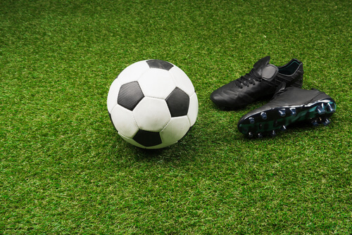 Close-up,Of,Soccer,Ball,With,Pair,Of,Black,Boots,On